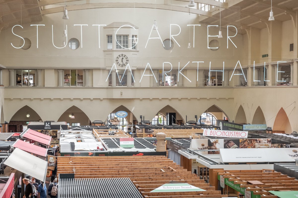 Interior image of Stuttgart's Markthalle from above. Vendors crowd the Markthalle floor below.